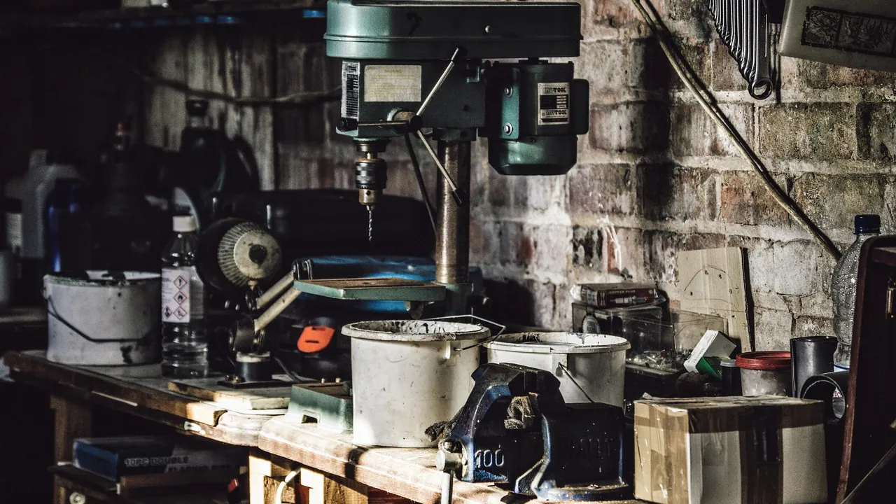 Un atelier : établi, perceuse à colonne et outils au mur